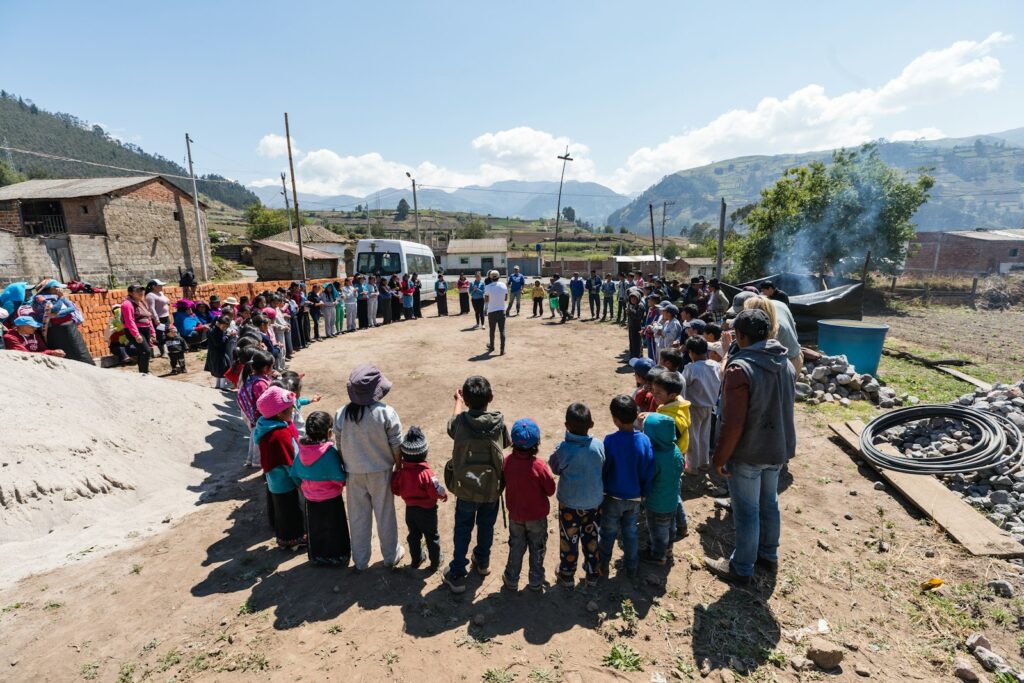 living faith,people standing forming circle near house under blue sky during daytime